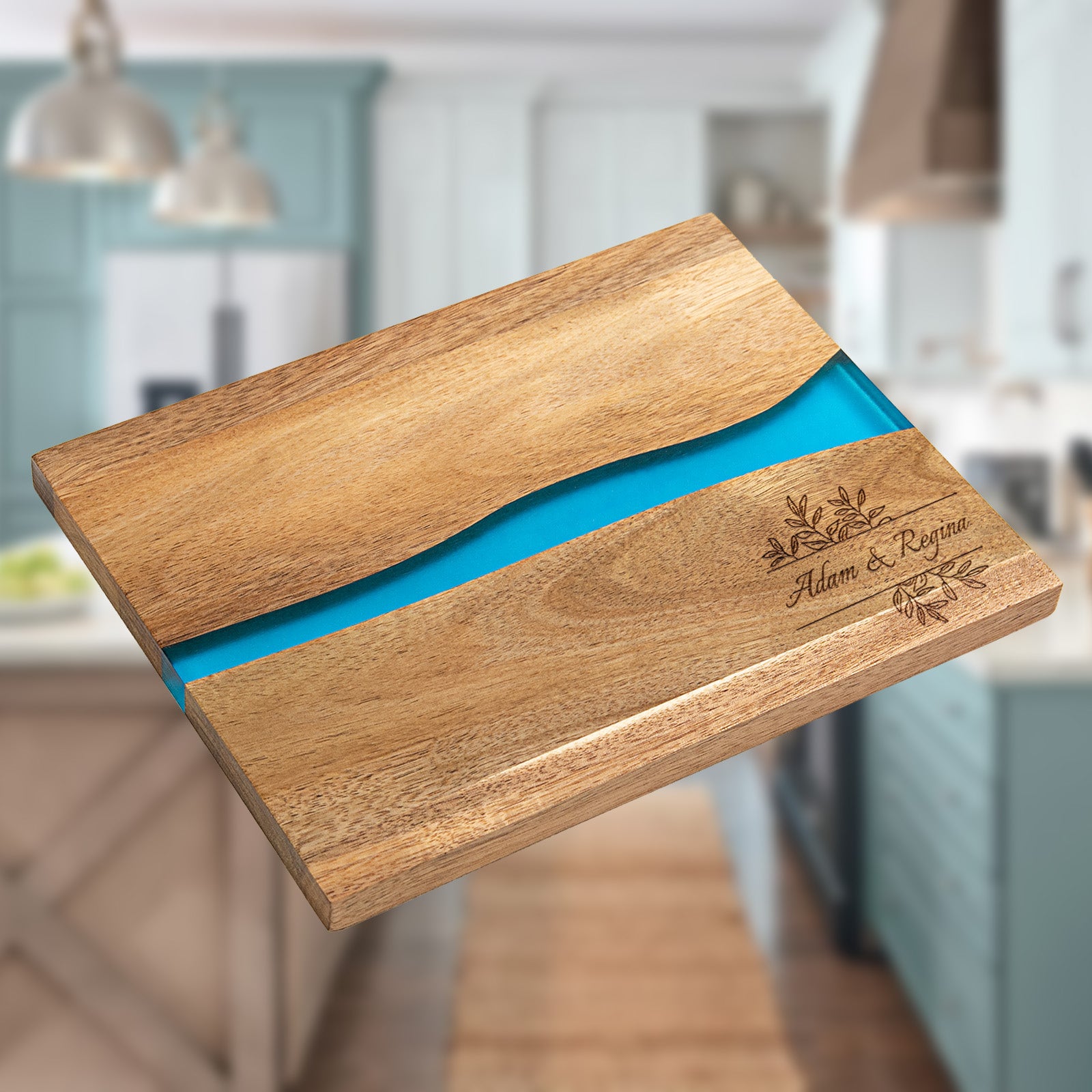 Personalized epoxy resin cutting board with blue river inlay and custom name engraving on natural acacia wood