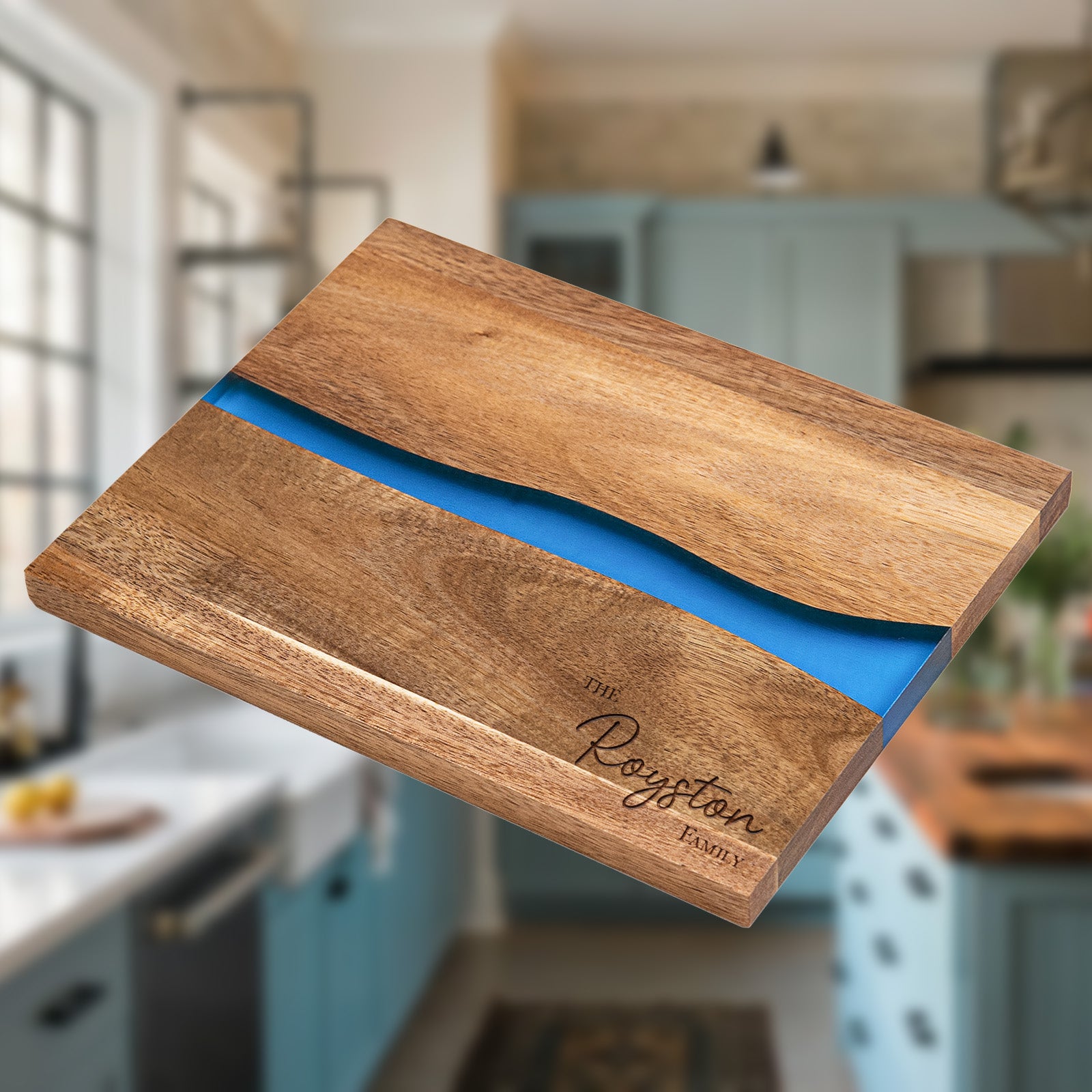 Personalized epoxy resin cutting board engraved with family name on natural acacia wood with blue river inlay